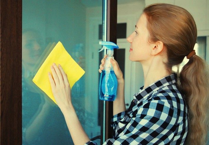 A woman in Pennsylvania cleaning a window with a rag, ensuring it sparkles and shines