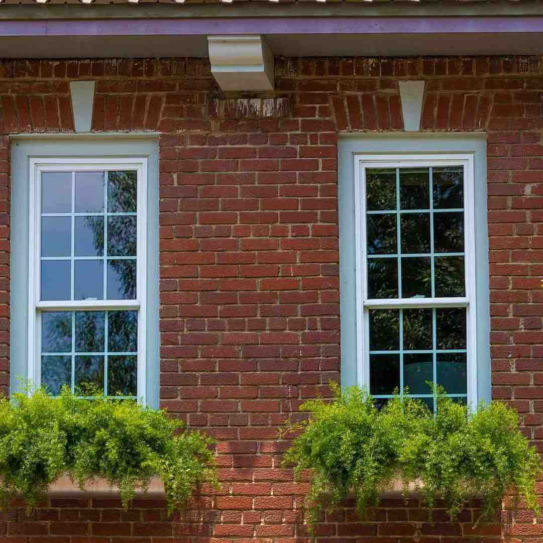 White double-hung replacement windows installed on a brick home exterior in Mechanicsburg, PA